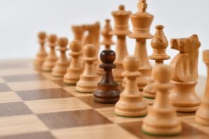 Chess pieces on a board viewed from above, symbolizing the hidden moves cognitive biases make in everyday decisions